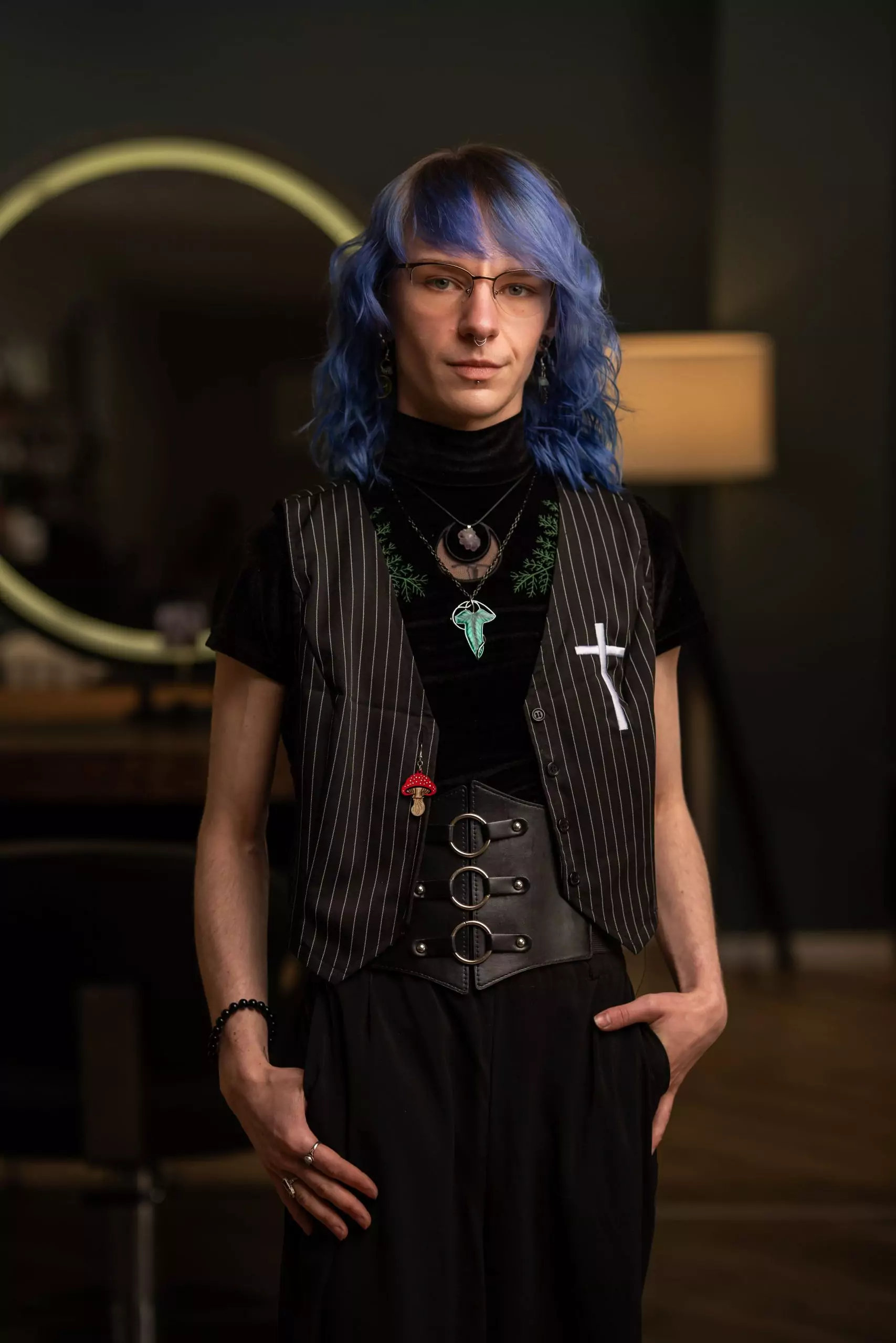 Theon, Friseur bei Jean&Jacqueline in Kassel, mit blauen Haaren und stilvollem Outfit im Salon – Experte für einfühlsame, neurodivergenzfreundliche Beratung.